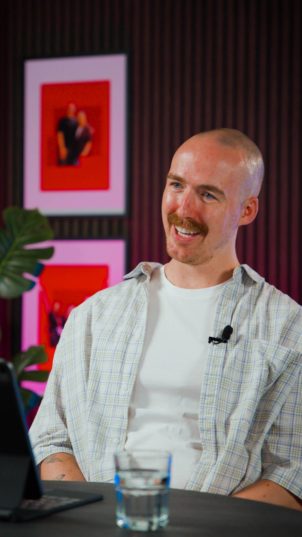 A guest mic'd up and smiling at the studio table